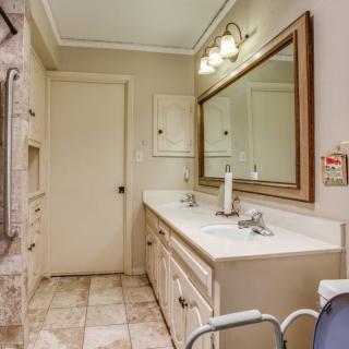 A clean and well-lit bathroom with a large mirror and double sinks.