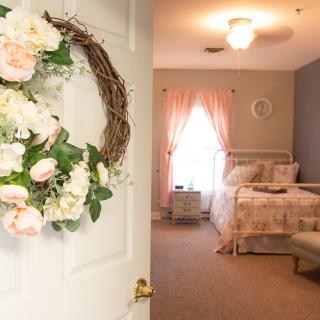 A cozy bedroom with floral decor and soft pastel colors.