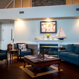 A cozy living room featuring elegant furniture and a beautifully decorated fireplace.