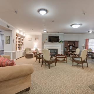 A cozy living room with seating area, bookshelves, and a fireplace.