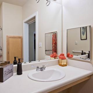 A tidy bathroom with a sink, mirror, and decorative items.