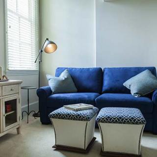 A cozy living room with a blue sofa and stylish decor.