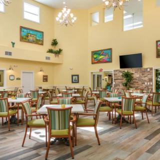 A spacious dining area with elegant furnishings and artwork adorning the walls.