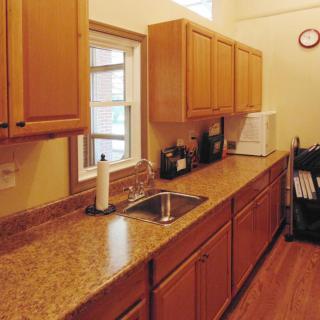 A kitchen featuring wooden cabinets and a granite countertop.