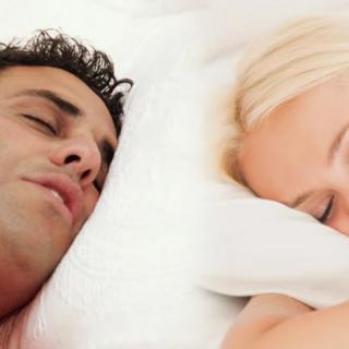 A couple peacefully sleeping in bed.