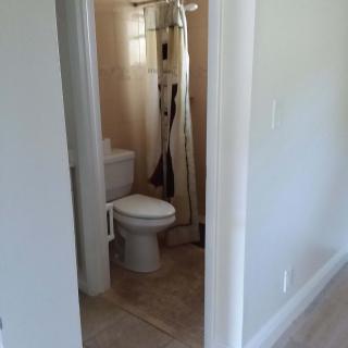 A view of a small bathroom with a toilet and shower.