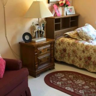 A cozy bedroom with floral bedding and classic wooden furniture.