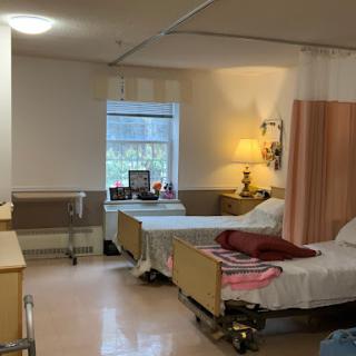 A view of a hospital patient room featuring two beds and medical amenities.