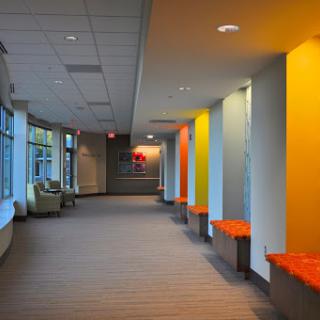 A vibrant and modern hallway featuring colorful walls and a comfortable sitting area.