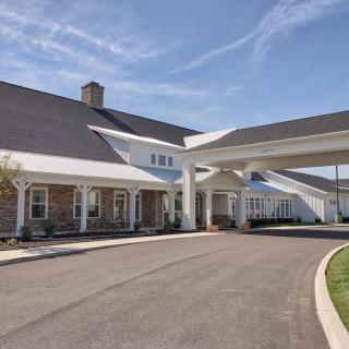A large building with a covered entrance and driveway.