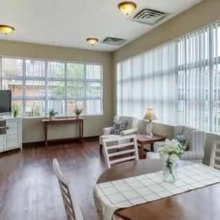 A bright and airy living room featuring large windows, wooden flooring, and comfortable seating.