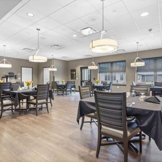 A modern dining area with neatly arranged tables and chairs, complemented by stylish lighting.