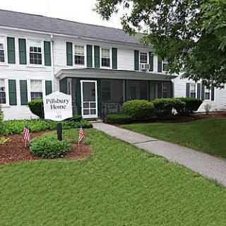 A two-story residential house with a front lawn and pathway leading to the entrance.