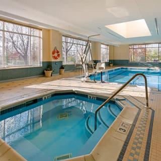 An inviting indoor pool area featuring a hot tub and large swimming pool, perfect for relaxation.
