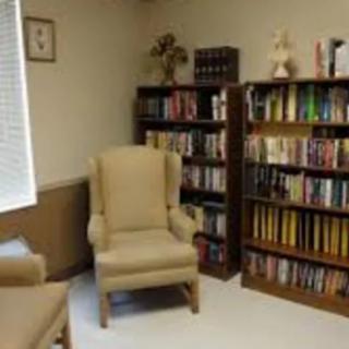 A cozy library corner with bookshelves and comfortable armchairs.