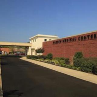 The entrance of a medical center with clear skies above.