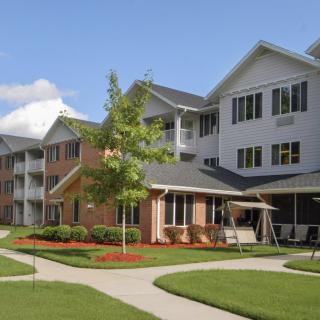 A residential apartment complex with landscaped lawns and pathways.