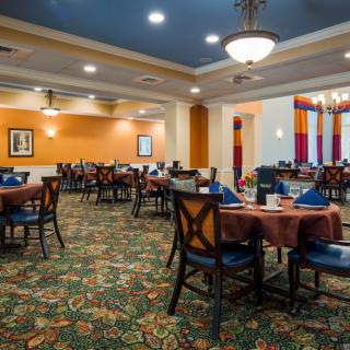 A spacious dining area with elegantly set tables and warm lighting.