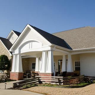 A suburban residential house with a front porch and well-maintained yard.