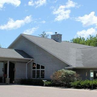 A view of a residential building with a sloped roof and clear sky.