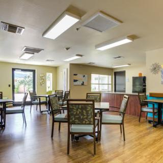 A spacious and well-lit dining area with tables and chairs arranged for communal meals.