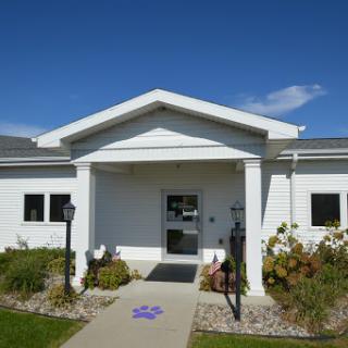 A bright and inviting white building with a well-maintained entrance and landscaping.