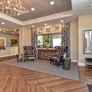 A modern lobby featuring elegant furniture and a striking chandelier.