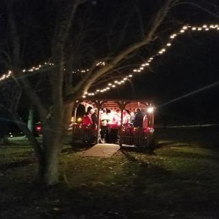 A beautifully decorated gazebo illuminated by string lights, creating a warm ambiance on a peaceful night.