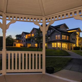 View of a residential building at dusk from inside a gazebo.