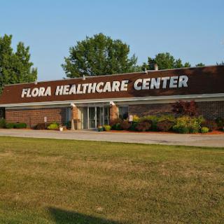 Exterior view of the Flora Healthcare Center, showcasing its welcoming entrance and surrounding greenery.