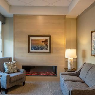 A cozy living room with modern furniture and a warm fireplace.