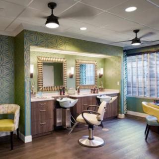 A modern beauty salon interior with stylish chairs and illuminated mirrors.
