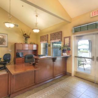 A well-lit reception area with a wooden desk and comfortable seating.