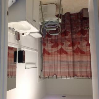 A minimalist bathroom featuring a sink, mirror, and patterned curtain.