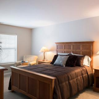 A cozy bedroom with a wooden bed and warm lighting.