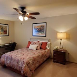 A cozy bedroom featuring a comfortable bed, stylish decor, and warm lighting.