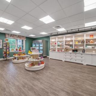 A well-organized retail store interior with products displayed on round tables and shelves.