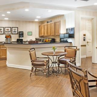 A cozy cafe-style kitchen with wooden flooring and seating.