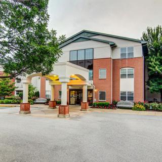 Entrance of a modern brick building surrounded by trees.