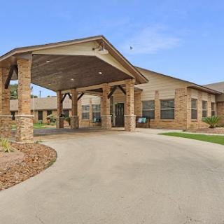 Welcoming entrance of a residential facility surrounded by landscaped grounds.