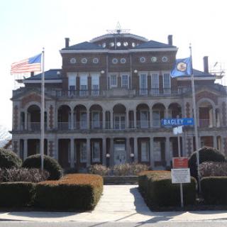 An elegant historic building featuring multiple flags, showcasing classic architectural design.