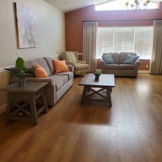 A cozy living room with modern furniture and ample natural light streaming in through the windows.