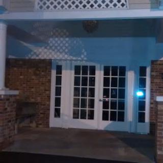 A view of a building's entrance at night, featuring glass doors and soft lighting.