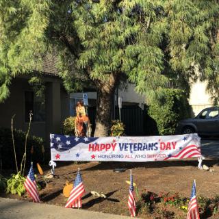 A festive display in honor of Veterans Day, featuring a large banner and American flags.