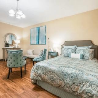 A well-decorated bedroom featuring a comfortable bed, elegant furniture, and stylish decor.