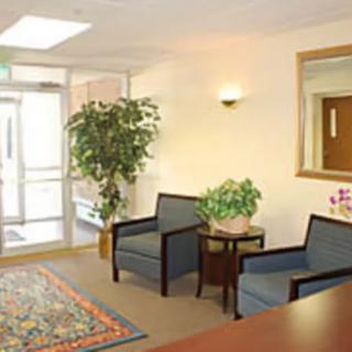 A small office lobby with chairs, a table, and potted plants.