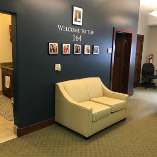 A welcoming lobby area featuring a light-colored sofa and decorative photos on the wall.