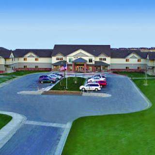 Aerial view of a modern residential facility with ample parking and landscaped grounds.