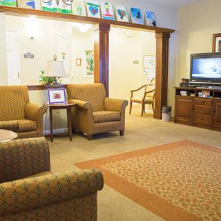 A cozy living room with comfortable seating, a television, and elegant wooden furnishings.