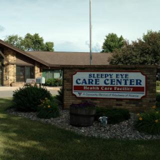 The exterior of a care center, featuring a welcoming sign and landscaped surroundings.